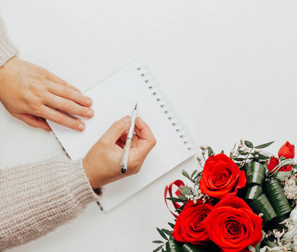 пустой блокнот, ручка и цветы на деревянном столе, вид сверху, плоский уголок