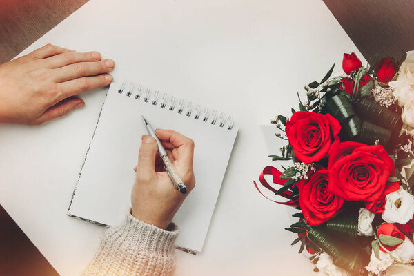 пустой блокнот, ручка и цветы на деревянном столе, вид сверху, плоский уголок