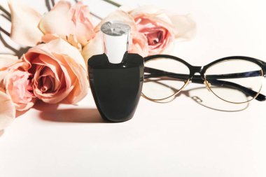 Çiçeklerin arka planında parfüm şişesi