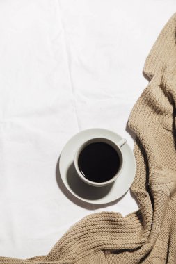Bir fincan kahve ve yatağın üzerine bir battaniye. Ev konforu kavramı