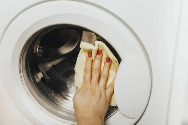 妇女用抹布清洁洗衣机的特写镜头 — 图库照片