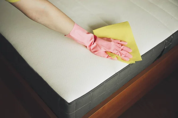 女性の手は黄色のラグでベッドをきれいに — ストック写真