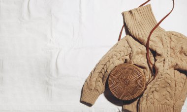 Kadın kış süveteri şık çantalı, beyaz manzaralı.