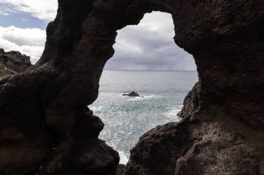 Tenerife 'deki deniz manzarası kayadaki bir delikten geçiyor.
