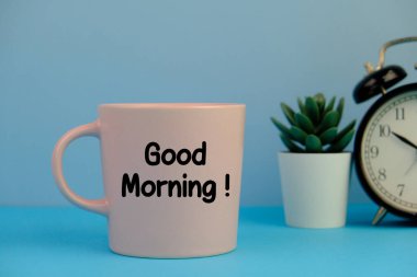 Good morning message on coffee cup at blue workplace background
