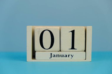 January 1st. Day 1 of month, calendar on business office table, workplace at yellow background. Spring time