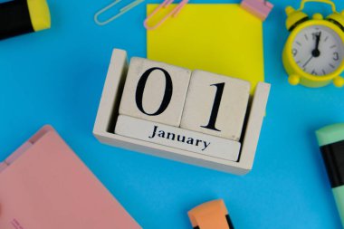 1 Ocak. Ayın ilk günü, çalışma masasında takvim, mavi arka planda iş yeri. eğitim kavramı