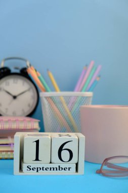 September 16, calendar on business office table, workplace at blue background. School concept.