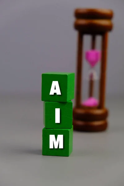 letters of the alphabet with AIM words on wooden block isolated on grey background