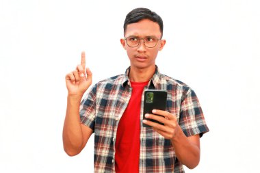 Sol eliyle cep telefonu tutan Asyalı bir adam, düşünceli bir yüz ifadesi sergiliyor..