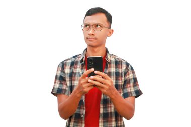 Asyalı bir adam elinde cep telefonu tutarken düşünceli bir ifade sergiliyor..