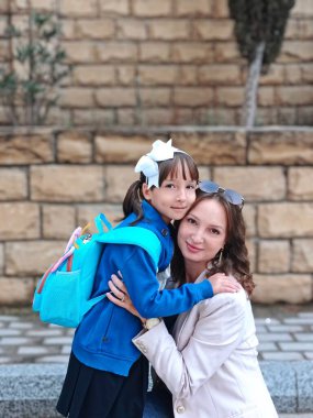 Küçük liseli kız ve annesi dışarıda. 