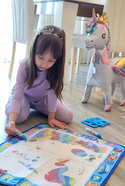 Küçük kız su kalemiyle özel çizim minderini çiziyor. Yüksek kalite fotoğraf