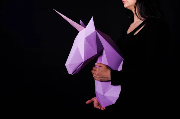 Hands hold violet unicorn. Artwork. 3d model unicorn papercraft. Copy space