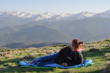 Yerde yatan ve dağın tepesinden manzarayı mutlu turizm seyahat