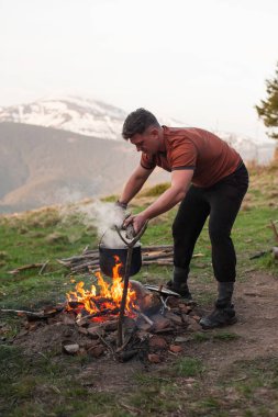 Bir kamp ateşi dağlarda pişirme
