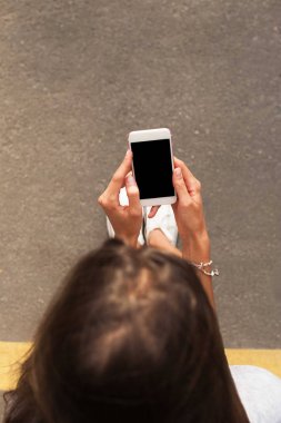 Bir kadın bir akıllı telefon sokakta kullanır.