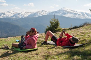 İki gezginler uyku tulumları üstüne yatan ve dağların hayran