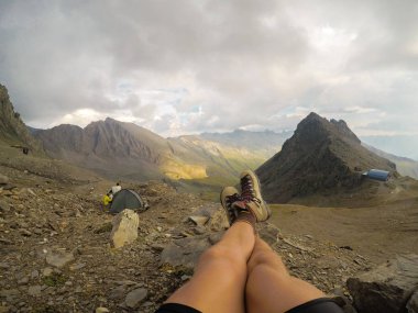 Arka planı dağların güzel bacaklar bir atlet dağcı gösterir