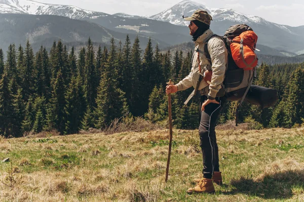 Um homem está no topo e admira as montanhas. — Fotografia de Stock