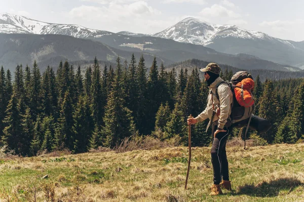 Un hombre se para en la cima y admira las montañas —  Fotos de Stock