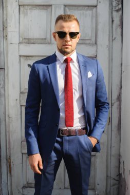 Güneş gözlüklü bir işadamı kameraya benziyor