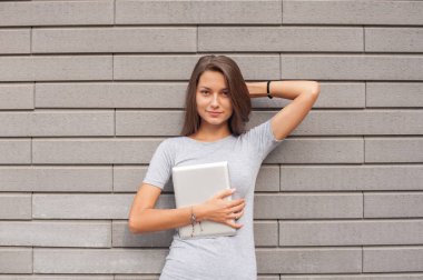 Sokakta bir tablet üzerinde çalışan genç iş kadını