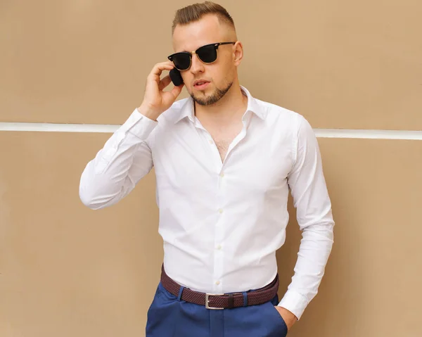 Always available. Man well groomed white shirt speak phone urban background. Businessman serious happy call mobile during lunch time. Guy handsome attractive office worker speak mobile phone.