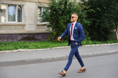 Güven her adımda. Tam takım bir güzel genç adam tam uzunlukta ileriye ceketini uyum sağlar..