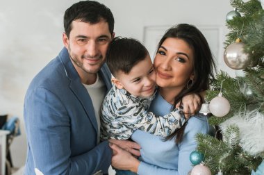Mutlu aile dekorasyon Noel ağacı birlikte. Baba, anne ve oğlu.
