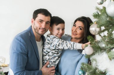 Mutlu aile dekorasyon Noel ağacı birlikte. Baba, anne ve oğlu.
