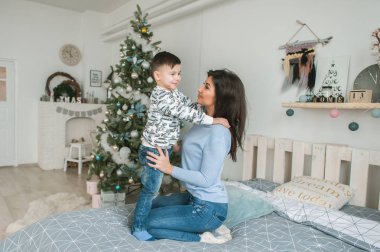 Anne ve oğlu yatağa otur. Noel.