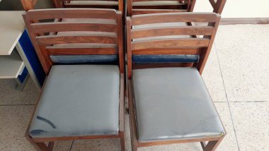 Wooden Chairs with Grey Cushioned Seats Showing Wear and Simple Slatted Design