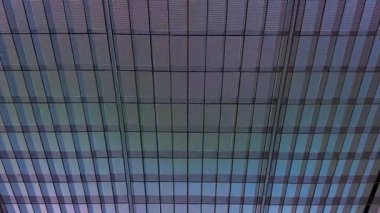 4k footage, close up of building glass window pattern with black metal frames in blue color. Blue tinted glass color as curtain wall. Seamless background texture.