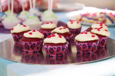Beyaz krema ve kalpleri bir ayna stand ile cupcakes.