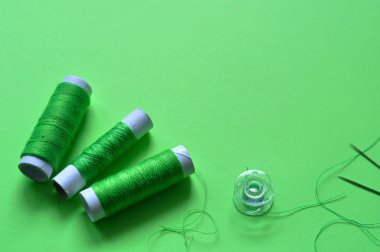 green thread reels for sewing on a green background. photo thread on. threads of shades of green. sewing, needlework, handmade. Use for backgrounds, wallpapers, posters, advertisements, card clipart