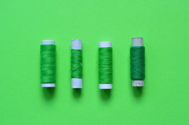 yeşil iplik makaraları yeşil bir arka plan üzerinde dikiş için. fotoğraf iş parçacığında. yeşil tonları konu. dikiş, dikiş, el yapımı. Kullanım için arka planlar, duvar kağıtları, afiş, reklam, kart