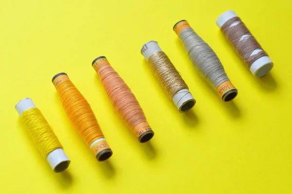 sarı iplik makara sarı bir arka plan üzerinde dikiş için. fotoğraf iş parçacığında. sarı tonları konu. dikiş, dikiş, el yapımı. Kullanım için arka planlar, duvar kağıtları, afiş, reklam, kart