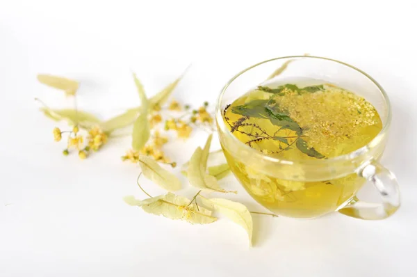 Fotoğraf şeffaf bir fincan bitkisel çay. çiçekler ve bitkilerin yaprakları. ıhlamur ve mürver, nane yaprakları çiçek. dinlenme zamanı. sıcak çay. kullanmak için arka plan, metin, tasarımınızın, kart