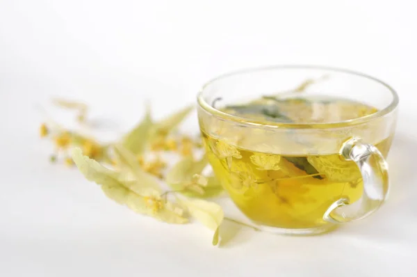 Fotoğraf şeffaf bir fincan bitkisel çay. çiçekler ve bitkilerin yaprakları. ıhlamur ve mürver, nane yaprakları çiçek. dinlenme zamanı. sıcak çay. kullanmak için arka plan, metin, tasarımınızın, kart