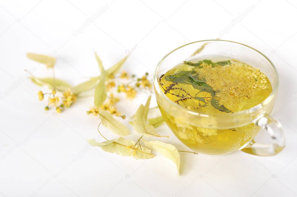 Photo of herbal tea in a transparent cup. flowers and leaves of herbs. flowers of linden and elderberry, leaves of mint. time for relaxation. hot tea. use for background, text, for your design, card