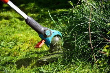 Hayatın basit anları, bahçede sıradan iş - adam bahçede ağır kırpma ile çim kırpma, uzun çim kenarları ve daha büyük zor erişim alanları kırpma için uygun