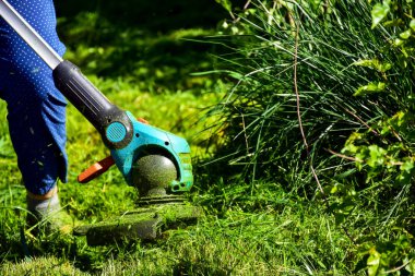 Hayatın basit anları, bahçede sıradan iş - adam bahçede ağır kırpma ile çim kırpma, uzun çim kenarları ve daha büyük zor erişim alanları kırpma için uygun