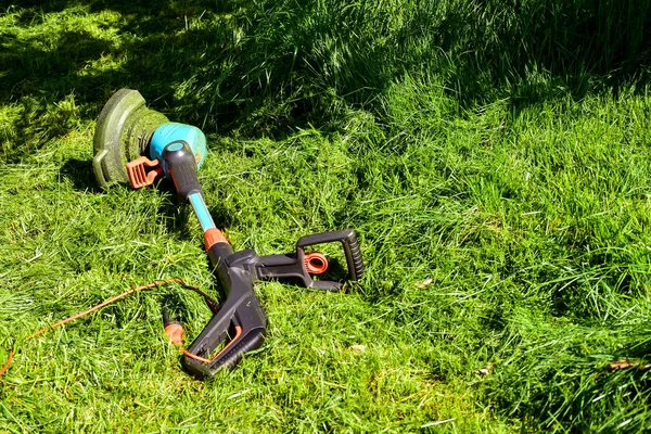 简单的生活时刻 在花园里的普通工作 人修剪草与重型修剪器在花园里 适合修剪长草坪边缘和更大的难以接近的区域 — 图库照片