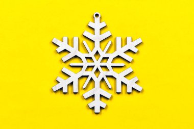 Sarı zemin üzerinde kontrplaktan yapılmış dekoratif bir kar tanesinin varyasyonları. Noel dekoratif unsurları