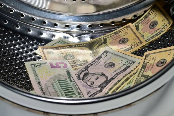 Banknotes in the washing machine, money laundering. Process of making illegally-gained proceeds (dirty money) appear legal (clean)