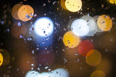 Gece yağmur. Pencere camına bokeh ışıklar.