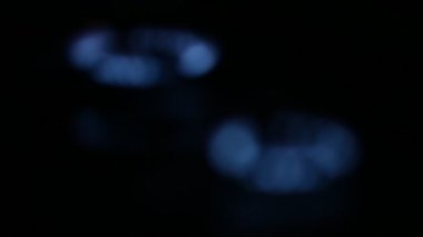 Gaz yakıcı karanlıkta. Mavi alevler odaklanır dönüşümlü olarak.