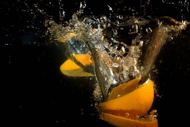 Ornage dilimleri. Siyah arka plan üzerinde hızlı hareket ile Splash su.