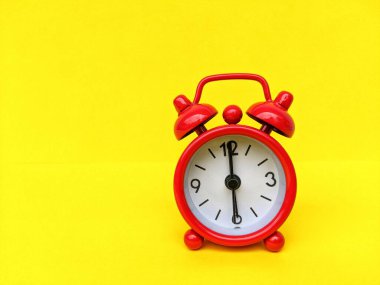 Sarı arka planda kırmızı alarm saati. Zaman yönetimi ve planlama kavramı